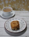 French pastry snack with cup of tea on saucer vintage Royalty Free Stock Photo