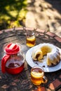 Tea in cup and teapot with bundt cake on picnic table outdoors Royalty Free Stock Photo