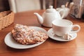 Tea cup, teapot and croissant on table in cafe Royalty Free Stock Photo