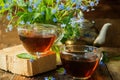 Tea cup, teapot, honey jar and summer bouquet of blue cornflowers on table outdoors. Summer still life.