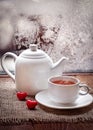 Tea cup and teapot with red hearts in winter frosty day Royalty Free Stock Photo