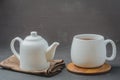 Tea. Cup of tea and teapot. White ware on a black stone table. Selective focus