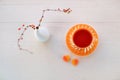 Tea cup, two sweets marmalade hearts and japanese vase with branches on white wooden background. Morning tea, vintage Royalty Free Stock Photo