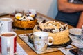 Tea cups mugs with two dessert cake tarts on wooden table at home