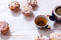 Tea cups, teapot and muffins on white wooden table, set teapot and brewed tea with cakes on table, green black herbal hot beverage