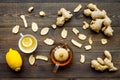 Tea for cure colds. Cup, teapot, ginger root and lemon on dark wooden background top view Royalty Free Stock Photo