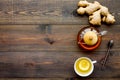 Tea for cure colds. Cup, teapot, ginger root and lemon on dark wooden background top view copy space Royalty Free Stock Photo