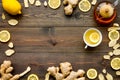 Tea for cure colds. Cup, teapot, ginger root and lemon on dark wooden background top view copy space Royalty Free Stock Photo