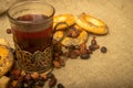 A faceted glass of tea in a vintage Cup holder, dried rosehip fruit and small bagels on a background of homespun fabric Royalty Free Stock Photo
