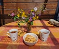 Tea drinking on the balcony. Two cups with tea and beautiful wildflowers on the table. Lunch time with cookies Royalty Free Stock Photo