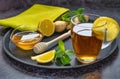 Tea in a glass cup with honey,ginger and lemon on a tray with green cloth image