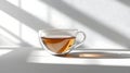 Tea in Glass Cup with Light and Shadow on White Surface Royalty Free Stock Photo