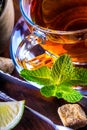 Tea in a glass cup, mint leaves, dried tea, sliced lime, cane sugar Royalty Free Stock Photo