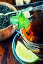 Tea in a glass cup, mint leaves, dried tea, sliced lime, cane sugar Royalty Free Stock Photo