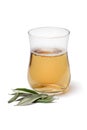 Tea glass with dried olive leaves tea and dried olive leaves in front on white background