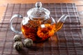 Tea in a glass teapot with a blooming large flower. Teapot with exotic green tea-balls blooms flower. Tea ceremony Royalty Free Stock Photo