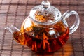 Tea in a glass teapot with a blooming large flower. Teapot with exotic green tea-balls blooms flower. Tea ceremony Royalty Free Stock Photo