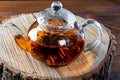 Tea in a glass teapot with a blooming large flower. Teapot with exotic green tea-balls blooms flower. Tea ceremony on a wooden Royalty Free Stock Photo