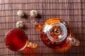 Tea in a glass teapot with a blooming large flower. Teapot with exotic green tea-balls blooms flower and a glass Cup of tea. Tea Royalty Free Stock Photo