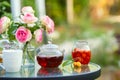 Tea in glass teapot. Romantic lunch in the garden. Summer time. Close up. Free space for text Royalty Free Stock Photo