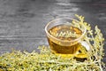 Tea of gray wormwood in glass cup on board