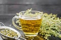 Tea of gray wormwood in glass cup with strainer on board