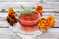 Tea herbal of marigolds in cup on board Royalty Free Stock Photo