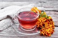 Tea herbal of marigolds in glass cup on old board Royalty Free Stock Photo