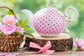 Tea kettle and basket with pink wild roses.