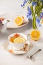 Tea with lemon and bouquet of blue primroses on the table