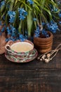 Tea with lemon and bouquet of blue primroses on the table