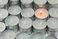 Tea lights candle with one being lit Royalty Free Stock Photo