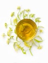 Tea from linden flowers with inflorescences of lindens around a cup on a white background. Top view. Vertical photo