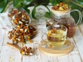 Tea made from dried flowers of calendula and marigolds on a wooden table and with green leaves in the background.The use of herbal Royalty Free Stock Photo