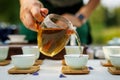 Tea master pouring green tea into white Chinese teacup