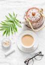 Tea with milk. Masala tea, teapot, cosmetics, lipstick, facial oil, glasses, green leaf flower on light background, top view. Cozy