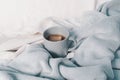 Tea mug on the bed. Cozy autumn background. Selective focus Royalty Free Stock Photo