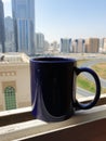 Tea mug in indigo at window view of the town. Royalty Free Stock Photo