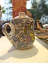 Tea mug with a lid, with beautiful asian painting on it and a finger handle, standing on white table