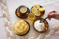 Tea in a painted Cup, on a saucer sliced lemon, pancakes, sour cream and a wooden spoon for overlaying. tea party in rustic style Royalty Free Stock Photo