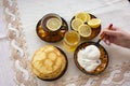 Tea in a painted Cup, on a saucer sliced lemon, pancakes, sour cream and a wooden spoon for overlaying. tea party in rustic style Royalty Free Stock Photo