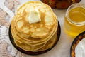 Tea in a painted Cup, on a saucer sliced lemon, pancakes, sour cream and a wooden spoon for overlaying. tea party in rustic style Royalty Free Stock Photo