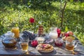 Tea, pancakes, milk and jam on the breakfast table in the autumn garden, close up Royalty Free Stock Photo