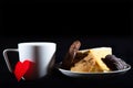 Tea cup of morning drink  waffles  biscuits and red heart on the black background. Romantic breakfast Royalty Free Stock Photo