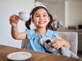 Tea party, happy girl and happiness of a young child on a home kitchen table with a smile. Play, fun and Asian kid from Royalty Free Stock Photo