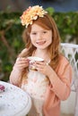 The tea party hostess. A cute little girl having a tea party outside. Royalty Free Stock Photo