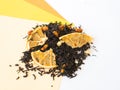 Tea with pieces of dried orange scattered on yellow and orange