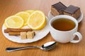 Tea, pieces of lemon, cinnamon sticks, sugar and cakes Royalty Free Stock Photo