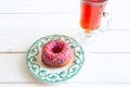 Tea and pink sugar donut on white wooden table Royalty Free Stock Photo