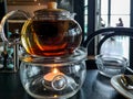 Tea pot above a candle with restaurant background Royalty Free Stock Photo